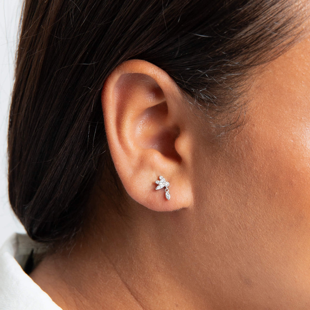 Close-up of an ear wearing a star-shaped earring with a blurred background