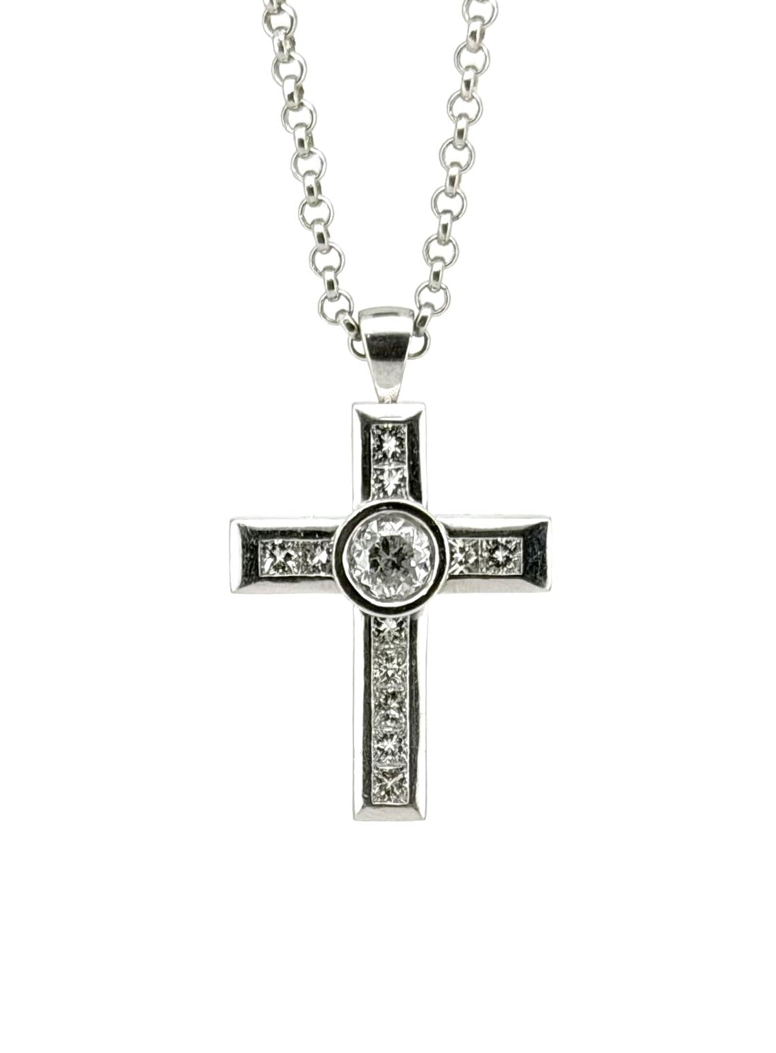 A silver cross pendant necklace with a central clear gemstone and small clear stones along the arms, suspended from a silver chain against a plain white background.
