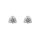 A pair of silver stud earrings with triangular prong settings holding clear round-cut gemstones, shown on a plain white background.