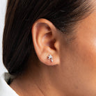 Close-up of an ear wearing a star-shaped earring with a blurred background