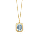 Gold necklace with a rectangular blue gemstone pendant on a white background