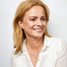 Woman with blonde hair wearing a white shirt against a light gray background