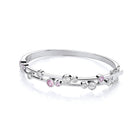 Silver bracelet with pink and clear gemstones on a white background