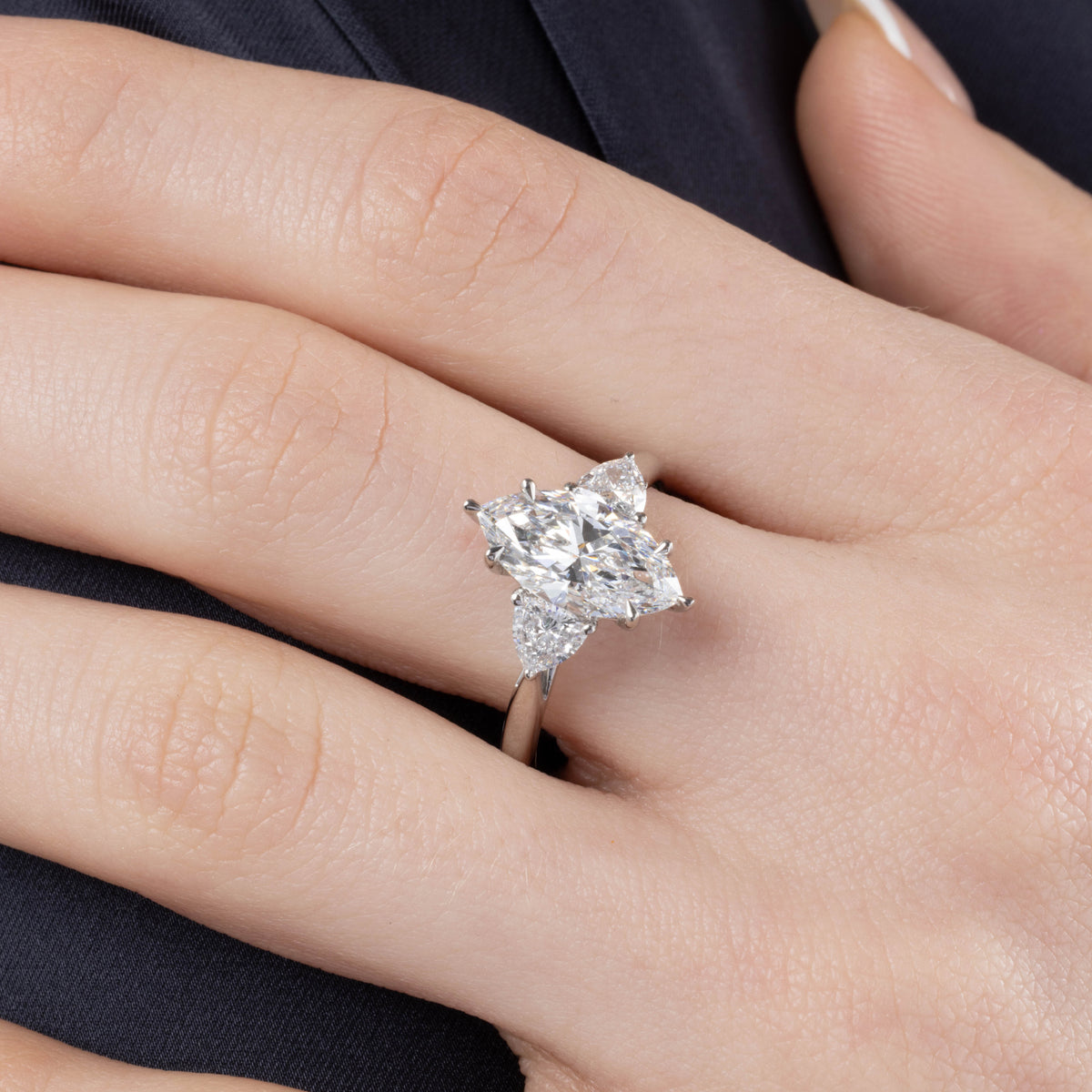 Diamond ring on a finger with a neutral background