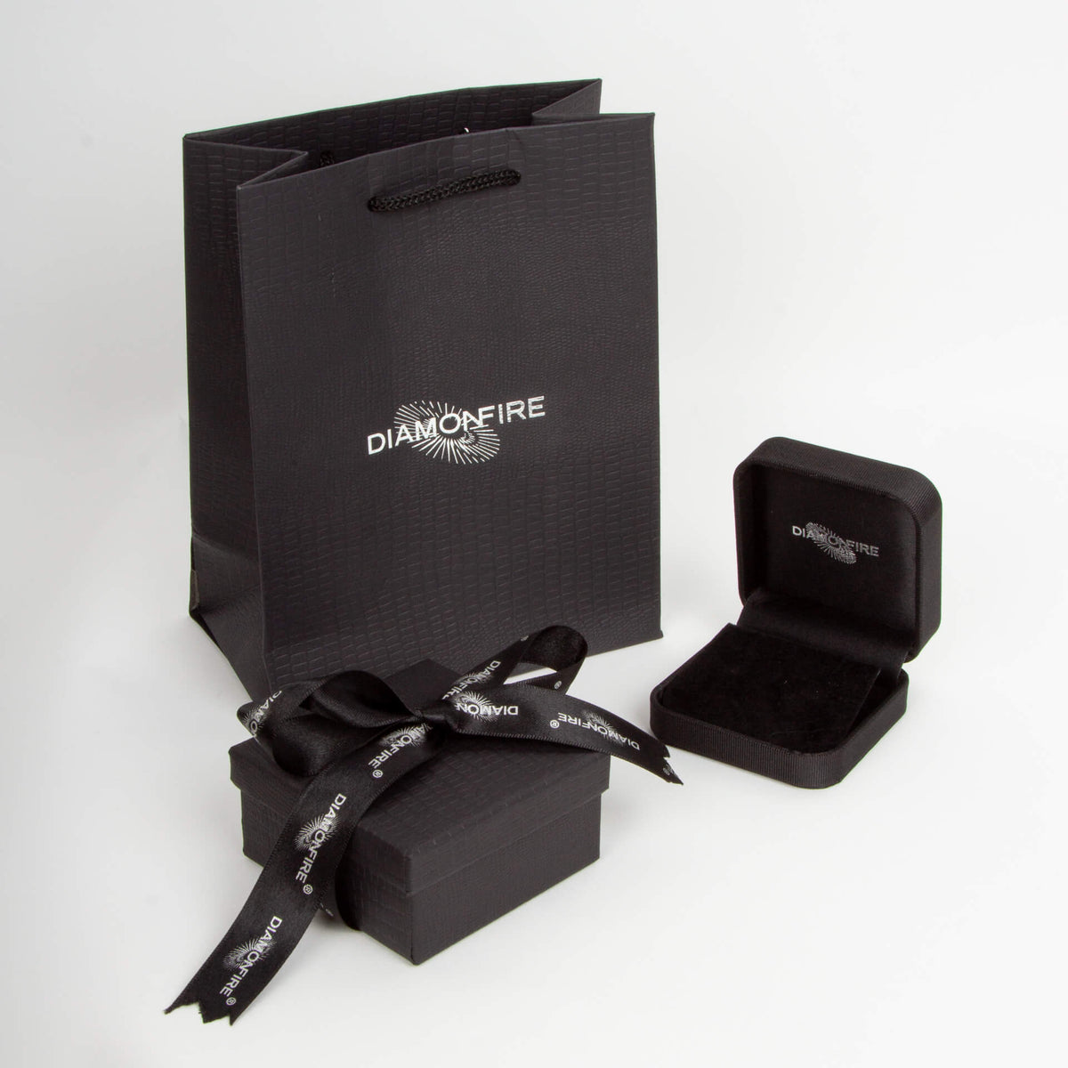 Black jewelry box with black ribbon and Diamonfire branded paper bag on a white background